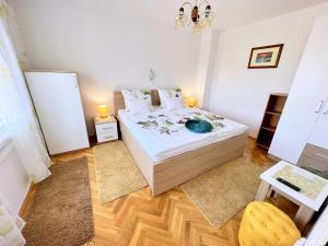 ein Schlafzimmer mit einem Bett mit weißen Laken und Kissen in der Unterkunft Mary Loo Apartments Rab in Rab