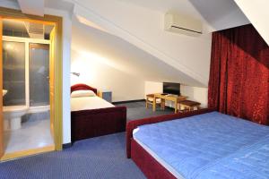 内乌姆Hotel Lav的配有床和电视的酒店房间