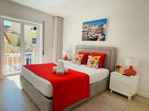 um quarto com uma cama grande e um cobertor vermelho em Central Tiled Apartment em Aveiro