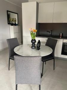a white table with chairs and a vase with flowers on it at Rijeka Relax Apartment with parking in Rijeka +28 photos