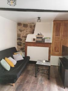ein Wohnzimmer mit einem schwarzen Sofa und einem Tisch in der Unterkunft Charmant petit studio proche départ GR20 in Calenzana