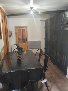 una mesa negra y sillas en una habitación con taquillas en Charmant petit studio proche départ GR20, en Calenzana