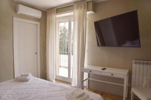 a bedroom with a flat screen tv on the wall at La Maison Latina Guest House in Latina