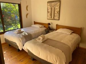 two beds in a room with a window at Casa Amatista Travels in Vicuña