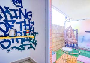a room with a chair and a wall with graffiti at Urban Escape - Piscine & Terrasse intime à 3 min du Parc des Coquibus - Proche ORLY in Courcouronnes