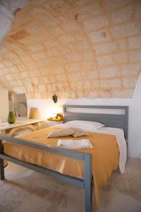 a bedroom with a bed and a stone wall at Masseria Piccole Taverne in Ostuni