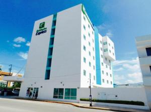 un gran edificio blanco con un cartel. en Holiday Inn Express Tuxtla Gutierrez La Marimba, an IHG Hotel, en Tuxtla Gutiérrez