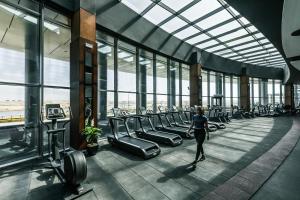 a woman walking through a gym with rows of chairs at Gewan White Beach Resort-New Alamein in El Alamein