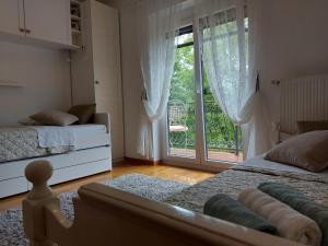 a bedroom with two beds and a large window at Apartman Doboga in Ozalj