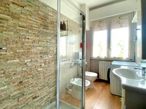 a bathroom with a shower and a toilet and a sink at Rho Fiera Milano Apartment in Pero