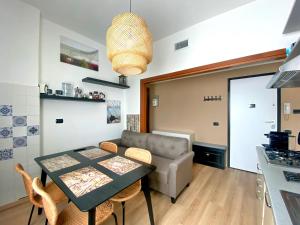 a kitchen and living room with a table and a couch at Rho Fiera Milano Apartment in Pero