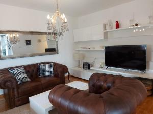 a living room with two leather couches and a flat screen tv at Apartman Doboga in Ozalj