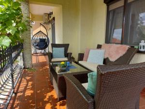 a patio with wicker chairs and a table on a porch at Apartman Doboga in Ozalj