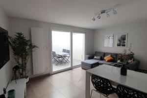 een woonkamer met een bank en een tafel bij Maison de ville 600 m du Marché in La Rochelle