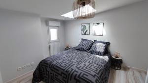 a bedroom with a bed and a chandelier at Maison de ville 600 m du Marché in La Rochelle