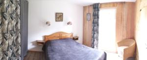 ein Schlafzimmer mit einem Bett mit einer blauen Decke in der Unterkunft Gîte Baden in Le Boulvé