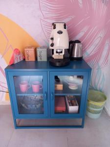 a blue cabinet with a coffee maker on top of it at 900 Bed and Breakfast in Nola