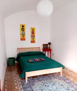 1 dormitorio con 1 cama verde y 1 alfombra en 900 Bed and Breakfast en Nola