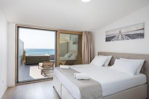 1 dormitorio con cama grande y ventana grande en Salt&Soul Residence, en Povljana