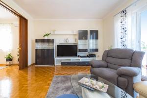 een woonkamer met een bank en een televisie bij Apartment Višnja in Zadar