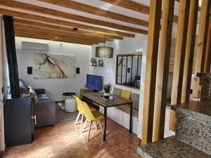 a living room with a desk and yellow chairs at El Rincón de Mariela By Travel Home in Segura de la Sierra