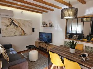 sala de estar con mesa y sillas amarillas en El Rincón de Mariela by Travel Home, en Segura de la Sierra