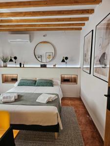 1 dormitorio con 1 cama grande y espejo en El Rincón de Mariela by Travel Home, en Segura de la Sierra