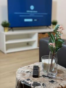 a table with a vase of flowers and a remote control at GROSS - REAL ESTATE in Leoben