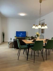 a dining room with a table and green chairs at GROSS - REAL ESTATE in Leoben