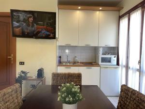 a kitchen with a table and a tv on the wall at Apt. Montesanto Sunset, 300Mt from city centre. in Pula