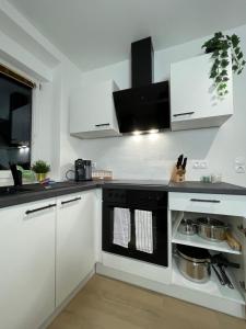 uma cozinha com armários brancos e um forno preto em GROSS - REAL ESTATE em Leoben