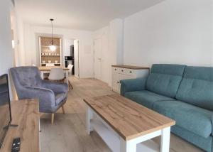 uma sala de estar com um sofá azul e uma mesa em Apartamento 4 Pax a 300m Playa con acceso a piscina MP 2H em Pals