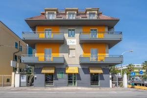 聖貝內代托德爾特龍托的住宿－Dea Suite Room，一座高大的橙色建筑,在街上设有阳台