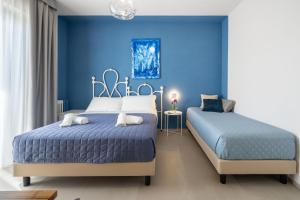 2 Betten in einem Schlafzimmer mit blauen Wänden in der Unterkunft Dea Suite Room in San Benedetto del Tronto