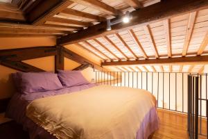 1 dormitorio con 1 cama en una habitación con techos de madera en Casale del Rosmarino - Suite Albicocca, en Montefiascone