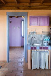 una cocina con armarios morados y fregadero en Casale del Rosmarino - Suite Albicocca, en Montefiascone