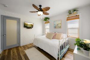 a bedroom with a bed and a ceiling fan at Little “house” right on the beach in Hollywood