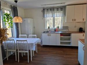 een keuken met een tafel en stoelen en een keuken met een tafel en een keuken bij Charmigt hus på landet nära till bad in Strömstad