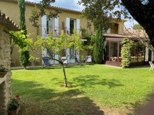 uma pequena árvore no quintal de uma casa em Logis La Bastide De Grignan Hotel & Restaurant "La Chênaie" em Grignan