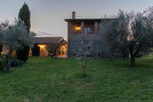 una casa en un patio con árboles delante de ella en Casale del Rosmarino - Suite Albicocca, en Montefiascone