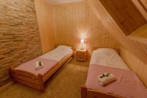two twin beds in a room with a brick wall at Apartament Kościeliska 10A in Zakopane
