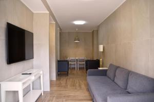 a living room with a couch and a tv at La Maison Latina Guest House in Latina