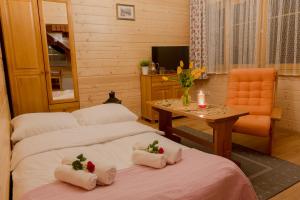 two beds in a room with a table and a chair at Apartament Kościeliska 10A in Zakopane