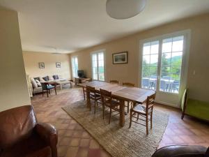 a living room with a wooden table and chairs at Maison dans les bois avec piscine in Encausse-les-Thermes