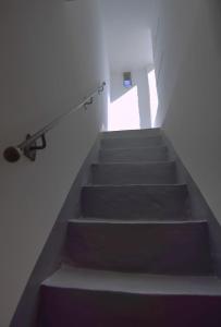 - un escalier dans une chambre blanche dotée d'une rampe d'escalier dans l'établissement La Biancasa, à Carovigno