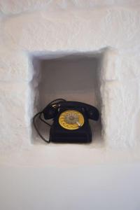 un téléphone noir à cordes dans un mur blanc dans l'établissement La Biancasa, à Carovigno