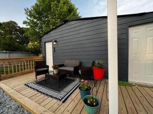 a deck with a black building and a white garage at The Double Door Inn - Unit 1 in Matthews