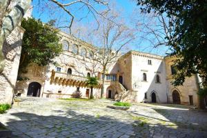 a large stone building with a tree in front of it at Una Biancasa in Carovigno