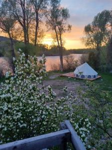 a tent sitting in the grass next to a lake at Snake River Glamping in Irwin