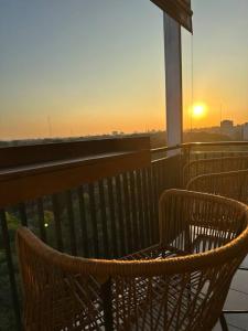 a balcony with two chairs and the sunset in the background at Chacarita Sunset l Andes Park in Buenos Aires